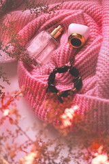 Fashion still life woman autumn clothes and accessories, perfume,  pink knitted scarf. Atmospheric mood