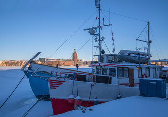 Moored boats at the pier Södermälarstrand. Icy bay Riddarfjärden, in background the Town City...