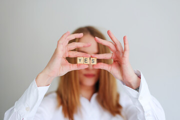 happy girl holding the letters YES in her hands. Focus on yes