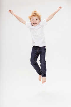 Studioportrait Junge barfuss in Jeans 