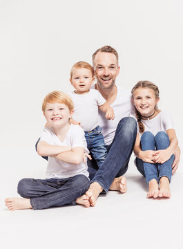 Vater mit drei Kindern Studioportrait in Jeans