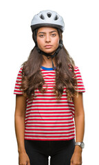 Young arab cyclist woman wearing safety helmet over isolated background with serious expression on face. Simple and natural looking at the camera.