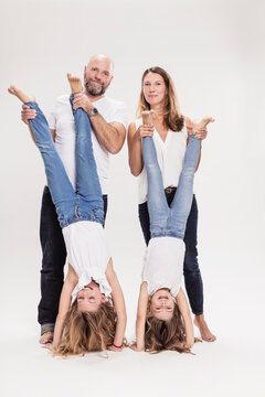 Studioportrait Familie mit zwei Kindern barfuss in Jeans