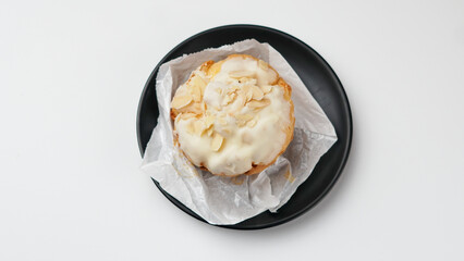 Freshly baked cream puffs or Vanilla eclairs with cream and nuts topping isolated on white background