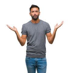 Adult hispanic man over isolated background clueless and confused expression with arms and hands...