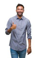 Adult hispanic man over isolated background doing happy thumbs up gesture with hand. Approving...