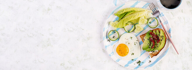 Romantic breakfast for Valentine's Day. Fried egg and toast with avocado and cream cheese. Top view, banner - obrazy, fototapety, plakaty