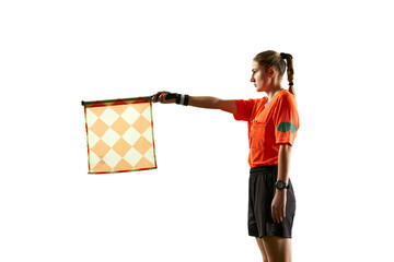 Assistant referee, young woman in uniform standing on field and raising flag up meaning offside...