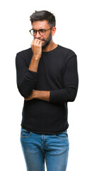 Fototapeta premium Adult hispanic man wearing glasses over isolated background looking stressed and nervous with hands on mouth biting nails. Anxiety problem.