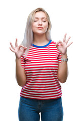 Fototapeta premium Young blonde woman over isolated background relax and smiling with eyes closed doing meditation gesture with fingers. Yoga concept.