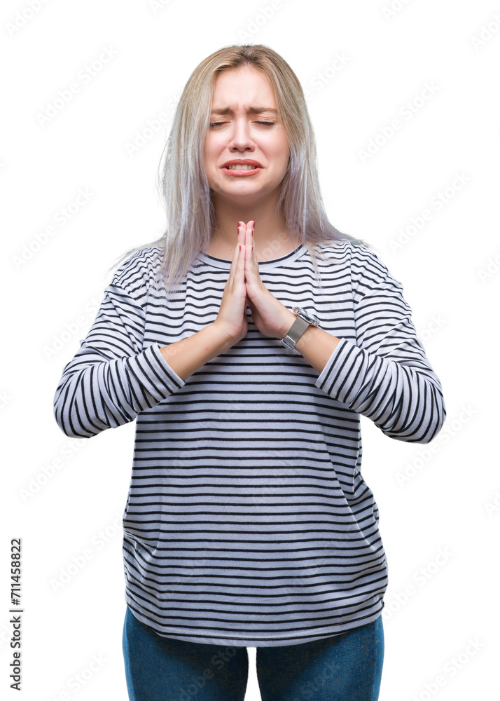 Sticker young blonde woman over isolated background begging and praying with hands together with hope expres