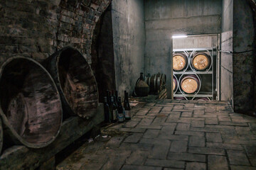 Traditional wine cellars with barrels, casks and stainless steel wine tanks - obrazy, fototapety, plakaty