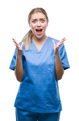 Young blonde surgeon doctor woman wearing medical uniform over isolated background celebrating mad...