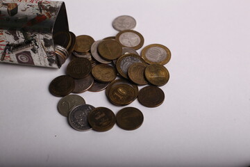 Coins spilling out of a paper bag on a white background.