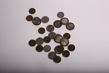 Coins spilling out of a paper bag on a white background.
