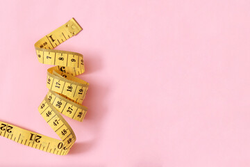 tape measure for obese people on a pink background soft focus