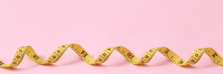 tape measure for obese people on a pink background soft focus - obrazy, fototapety, plakaty