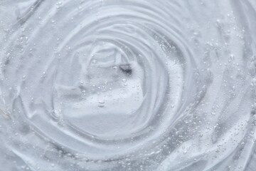 Clear cosmetic serum on white background, macro view