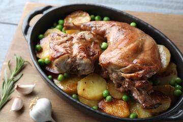 Tasty cooked rabbit with vegetables in baking dish on table, closeup