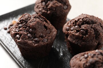 Delicious chocolate muffins on light table, closeup