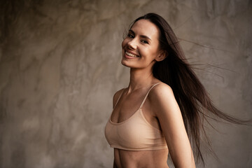 Fototapeta premium Photo of adorable happy woman in beauty studio love herself with no filters empty space isolated on grey concrete wall background