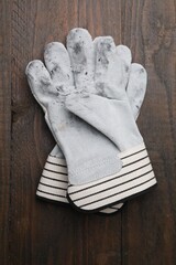 Pair of color gardening gloves on wooden table, top view