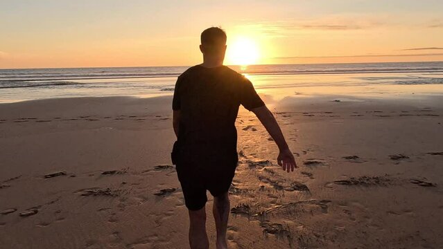 A man runs on the beach and does a backflip in slow motion in Morocco