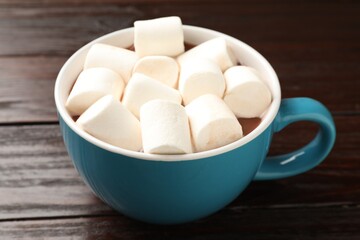Tasty hot chocolate with marshmallows on wooden table, closeup