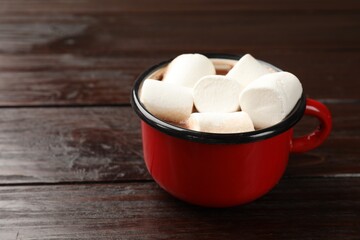Tasty hot chocolate with marshmallows on wooden table, closeup. Space for text