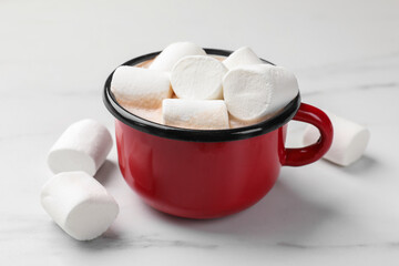 Tasty hot chocolate with marshmallows on white marble table, closeup