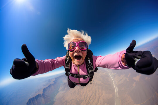 Cheerful old granny trying skydiving in the sky and showing thumbs up.