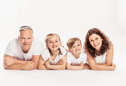 Studioportrait Familie mit zwei Kindern barfuss in Jeans