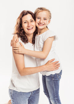 Studioportrait Mutter mit Tochter l&auml;chelnd in die Kamera barfuss in Jeans 