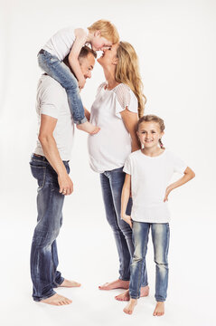 Studioportrait Familie mit zwei Kindern barfuss in Jeans