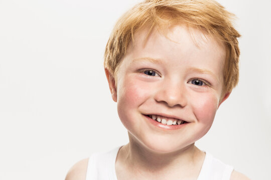 Studioportrait rothaariger Junge der lacht