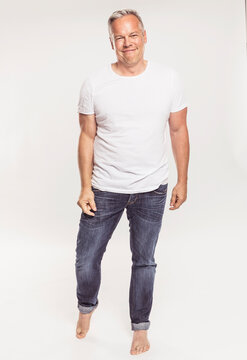 Studioportrait best ager Mann in Jeans lustig
