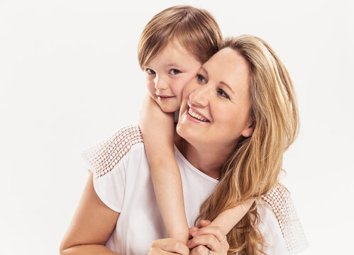 Studioportrait Mutter Kind barfuss in Jeans, lachen sich gegenseitig an