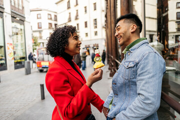 young couples in a relationship on the city street enjoying a fruit dessert on their Valentine's...
