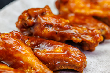 Plate of barbecue chicken wings on black background