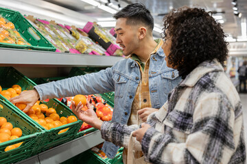 young multiracial couple in love shopping together in the supermarket