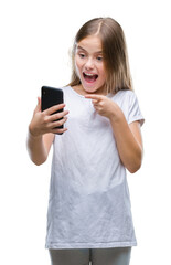 Fototapeta premium Young beautiful girl sending message texting using smarpthone over isolated background very happy pointing with hand and finger