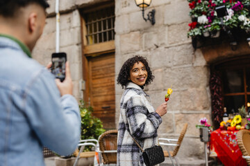 sightseeing on the city street, boyfriend takes photos of his girlfriend as a souvenir of their date for Valentine's Day