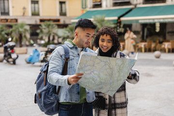 young multiracial couple looking at the map on their valentine's day anniversary trip