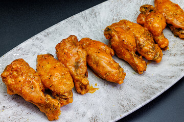 Plate of Buffalo chicken wings on a black background