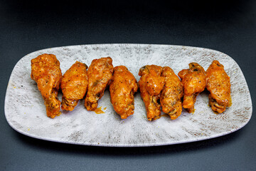 Plate of Buffalo chicken wings on a black background