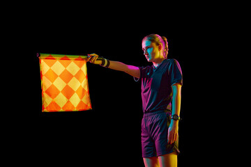 Young woman, assistant referee raising flag up meaning offside position against black studio...