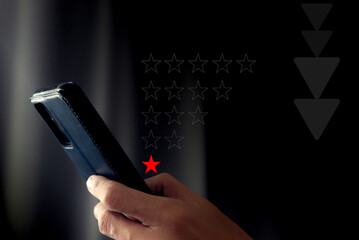 A businessman is rating his satisfaction with the services of his business. via mobile phone By giving a low rating of only 1 star, the concept is about the development and improvement