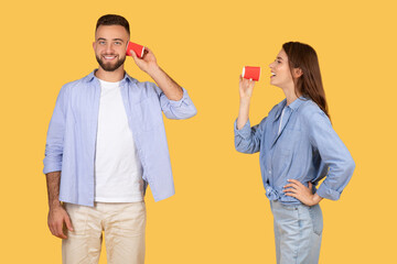 Man and woman communicating with red paper cups