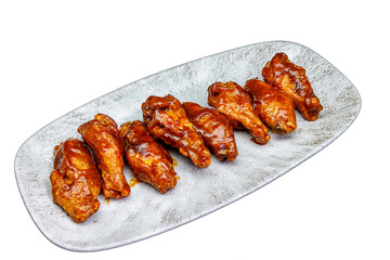 Plate of barbecued chicken wings on a white background