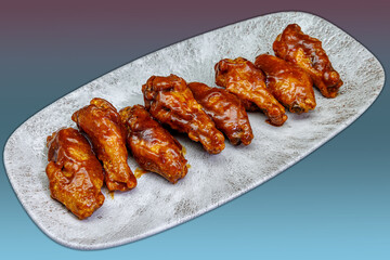 Plate of barbecued chicken wings on a magenta and light blue gradient background